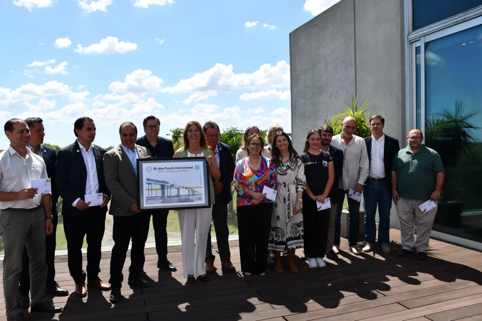 Con un acto institucional realizado en la sede de la Comisión Administradora del Río Uruguay (CARU), se conmemoraron los 50 años del Puente Internacional Paysandú–Colón, inaugurado el 10 de diciembre de 1975 y convertido en un símbolo de integración entre Argentina y Uruguay. La ceremonia reunió a autoridades nacionales, departamentales y municipales de ambos países, junto a referentes comunitarios, en una jornada que combinó memoria, reconocimiento y proyección hacia el futuro. Presencias institucionales y actividades conmemorativas Entre los participantes se encontraban la presidenta de la Delegación Uruguaya ante CARU, Cecilia Bottino; el intendente de Paysandú, Nicolás Olivera; y la intendenta de Colón en ejercicio, María Dalleves, además de autoridades nacionales, departamentales y exintendentes de ambas márgenes. Previamente al acto central, se desarrolló un desfile de embarcaciones de instituciones náuticas locales, seguido de un cierre cultural, en una propuesta que reforzó el carácter comunitario y binacional de la conmemoración. Discursos que resaltaron la hermandad regional Durante su intervención, la intendenta María Dalleves destacó que se celebraron “los 50 años de inauguración del puente General Artigas, un puente que nació con la finalidad de unir”, al tiempo que lo definió como “un símbolo tangible de la hermandad entre nuestros pueblos”. Por su parte, el intendente sanducero Nicolás Olivera subrayó que “no es cierto que el puente unió dos cosas, porque ya estaban unidas de antes”, e invitó a “pensar de acá para adelante”, poniendo el foco en los desafíos futuros de la región. En la misma línea, Cecilia Bottino remarcó que la conmemoración “era en conjunto o no era” y llamó a planificar el futuro de la infraestructura, recordando que “toda obra tiene un ciclo de vida”. Placas conmemorativas y proyección a futuro Luego de los mensajes oficiales, se realizó el descubrimiento de placas conmemorativas, reafirmando el valor del puente como una infraestructura estratégica para la integración, la cooperación y el desarrollo regional. El acto dejó en claro la necesidad de pensar políticas comunes que garanticen el mantenimiento, la modernización y la proyección de este paso internacional clave para la región de Salto Grande. Lanzamiento del sello conmemorativo por los 50 años En el marco de los homenajes, el 10 de diciembre se realizó en la sala de reuniones de CARU el lanzamiento oficial del sello conmemorativo por los 50 años del Puente Internacional General José Gervasio Artigas. La actividad contó con la presencia de la presidenta de la Delegación Uruguaya ante CARU, Dra. María Cecilia Bottino Fiuri, y del vicepresidente del Correo Uruguayo, José Luis Pereira, junto a delegados uruguayos ante el organismo, autoridades departamentales de Paysandú, ediles, representantes educativos, organizaciones sociales y funcionariado de CARU. La emisión del sello fue destacada como un hito de alto valor histórico y simbólico, que reconoce al puente como una infraestructura que, desde hace medio siglo, fortalece los vínculos entre la República Argentina y la República Oriental del Uruguay.